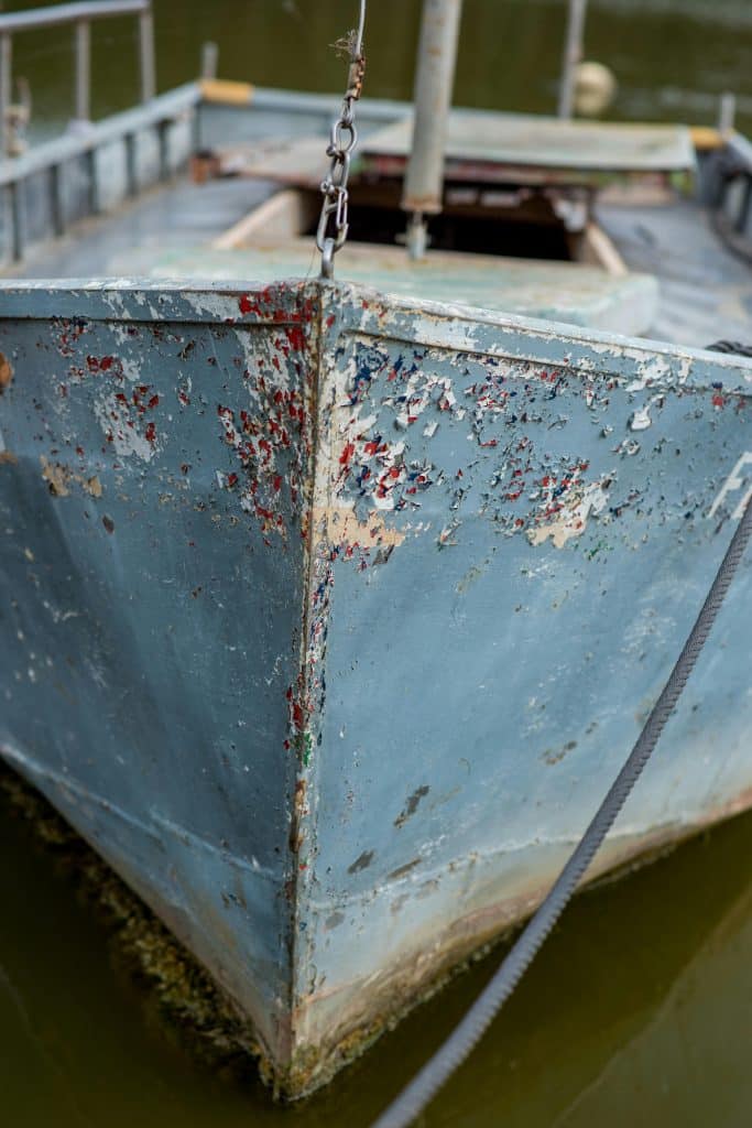Close-up of a vintage boat's front with weathered paint, exuding a rustic charm.